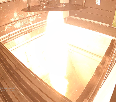 Captured frame of a powerful hybrid engine ground test, with an intense vertical flame illuminating the test chamber.